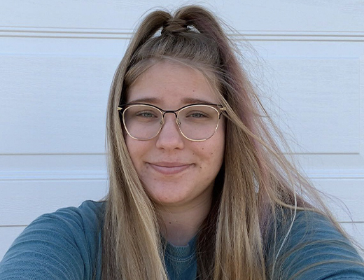 Maren in front of a white brick wall